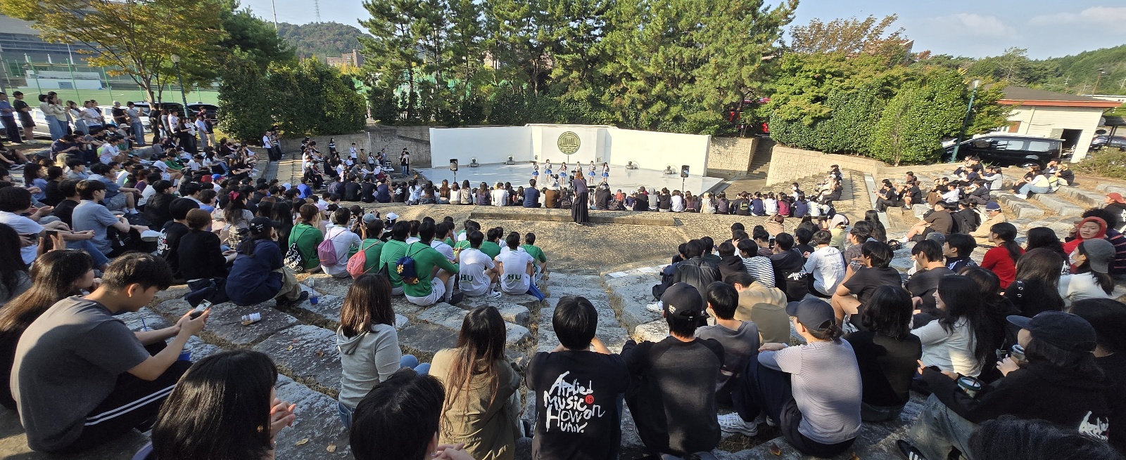호원대학교 학생들이 야외 음악홀 객석에서 공연을 관람하고 있다